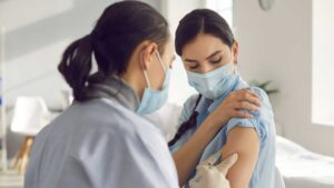 médecin qui fait un vaccin à sa patiente